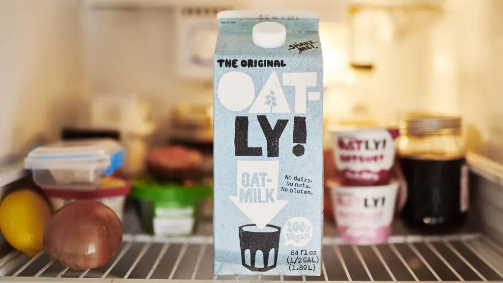 A carton of Oatly in a fridge.