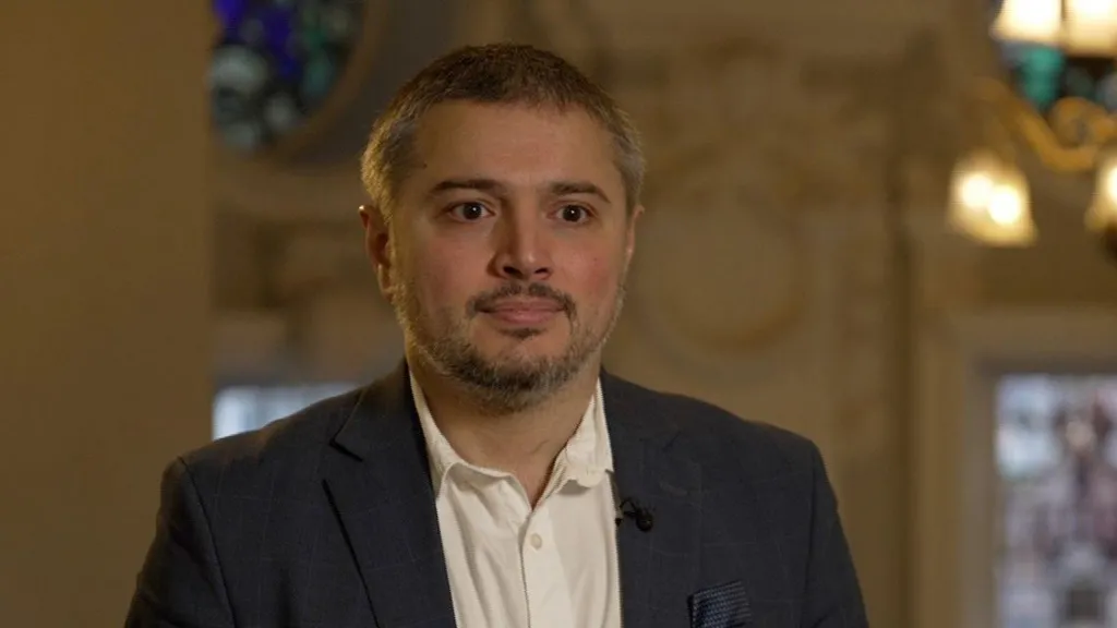 Danny Adilipour wearing a white shirt and dark jacket