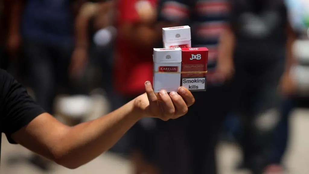 File photo showing a Palestinian man selling cigarettes on a street in Deir al-Balah, in the central Gaza Strip, on 12 June 2024