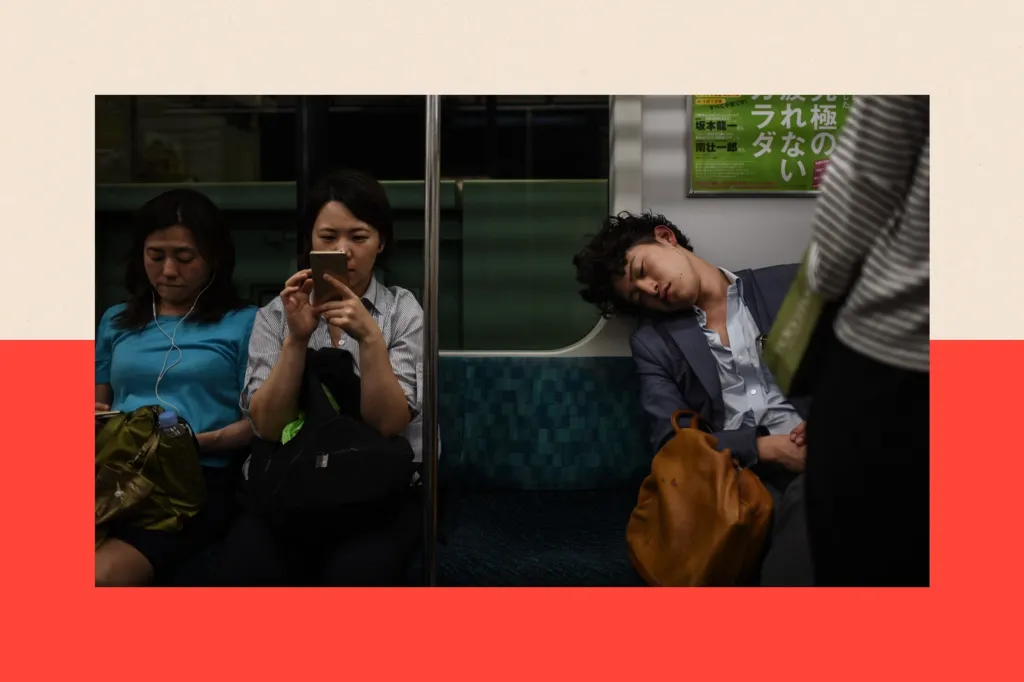 Three people on an underground train carriage. The man on the right is asleep