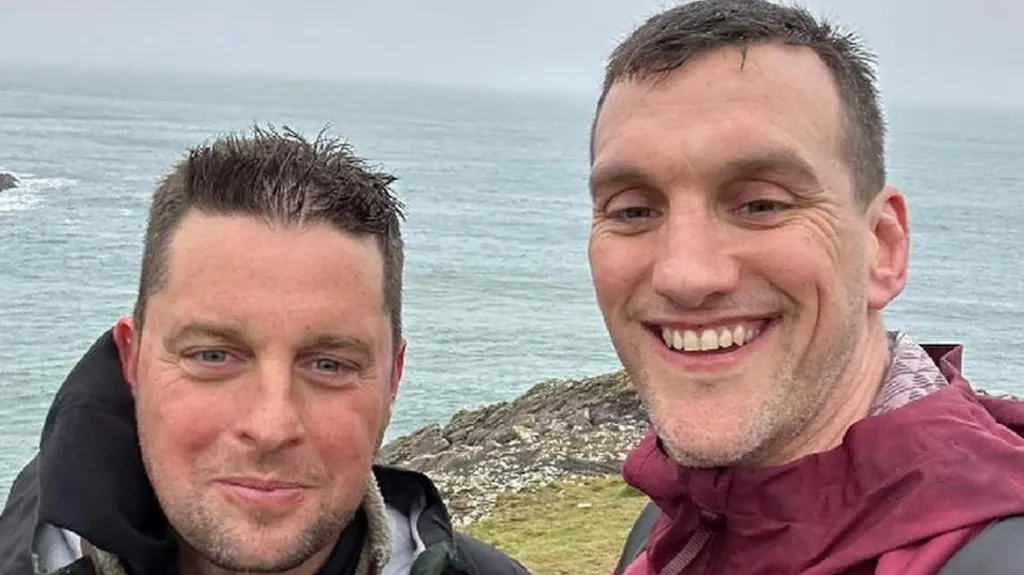 Craig smiling with Sam Warburton. They are stood near a cliff edge with the sea in the background.