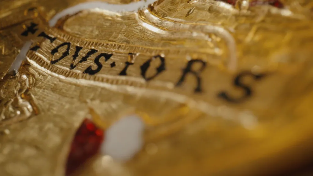 A close-up image of the pendant, showing the letters "tousiors" in detail