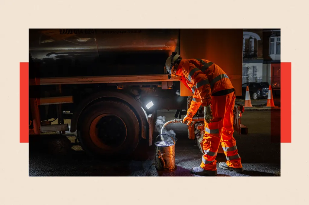 Road workers laying Hot Rolled Asphalt during a night time road closure 