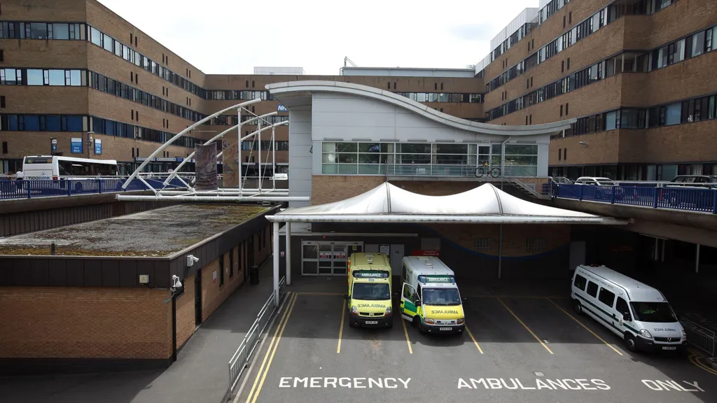 Queens Medical Centre (QMC) a light brick building with ambulances parked out the front