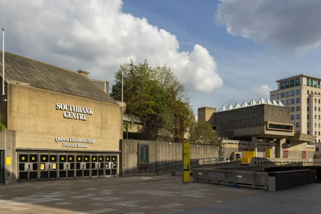 A brutalist building and the entrance to the Queen Elizabeth Hall. Outside is plain brown concrete. 