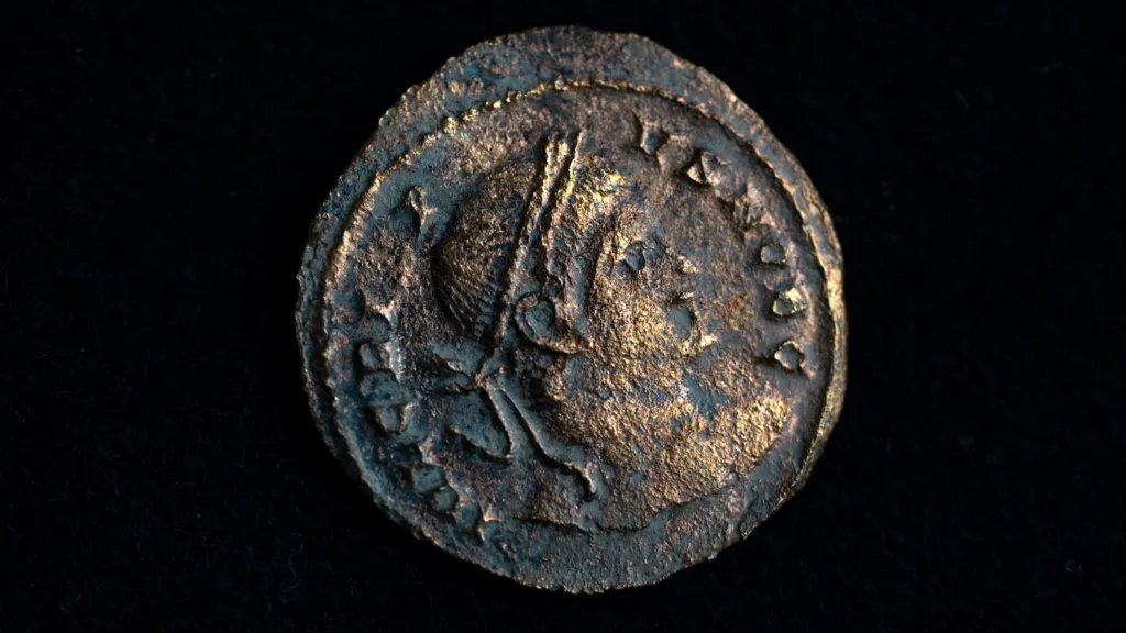 A close up of a Roman coin with detail found during HS2 archaeological excavations