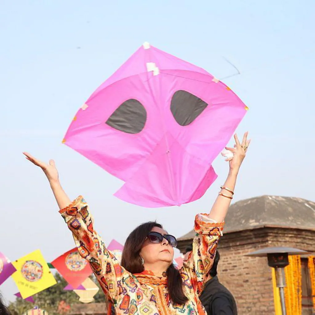 A woman holds a kite above her head during the Basant kite festival in Lahore, Pakistan.