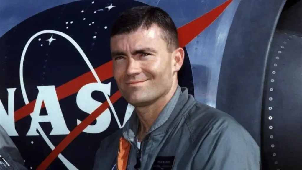 Fred Haise smiles as he stands in front of a Nasa training jet