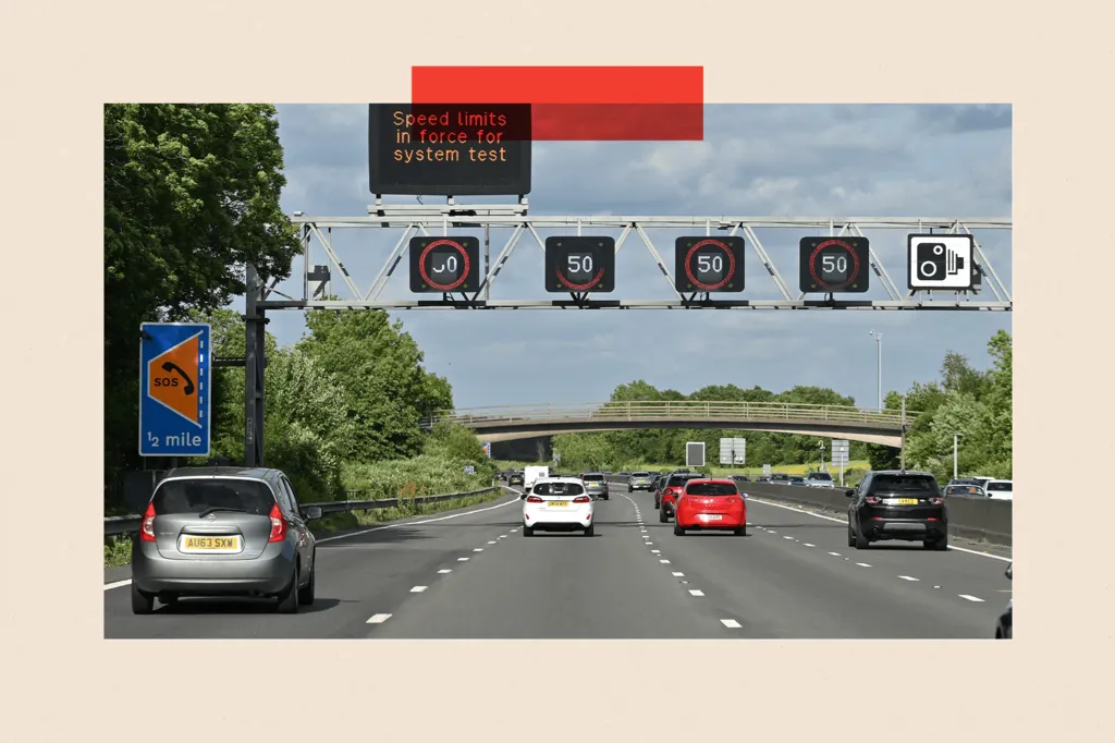 Cars travel along the M25 Motorway as the variable speed limit shows 50mph