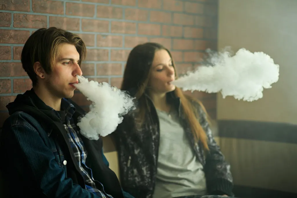 Teenagers blowing smoke