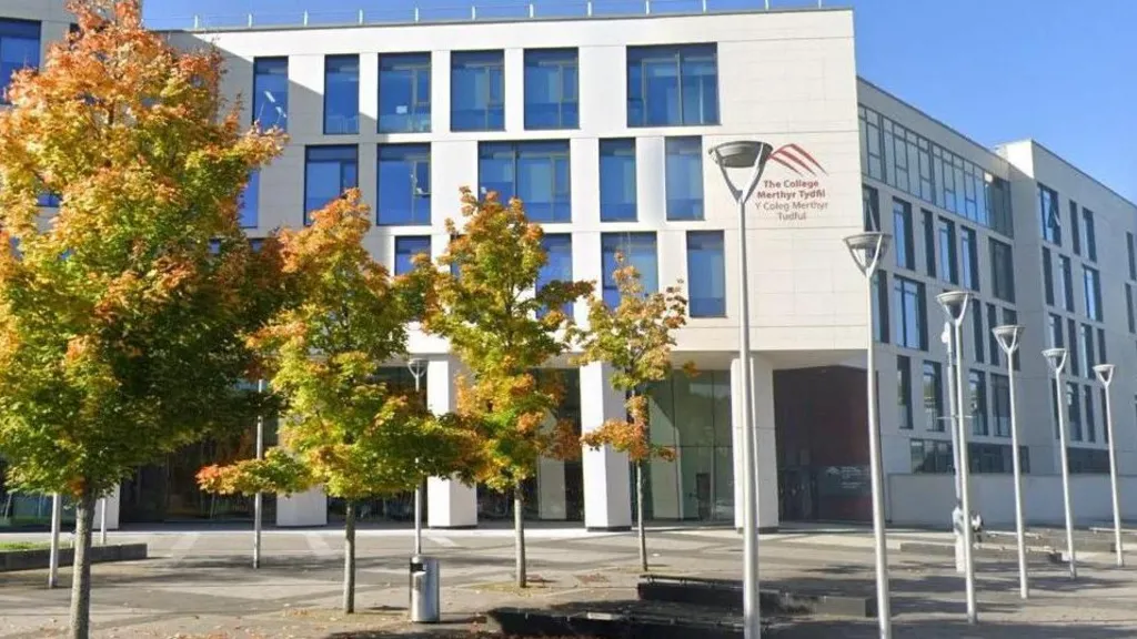 Image shows exterior of Merthyr Tydfil, a modern white building with blue windows