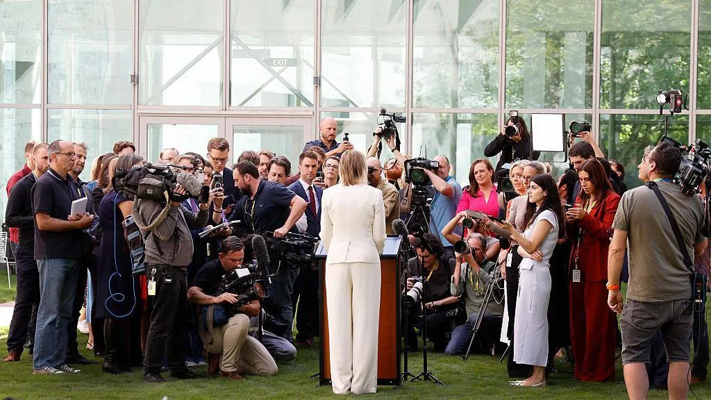 Sussan Ley, wearing a cream suit, surrounded by a press park in the parliament courtyard