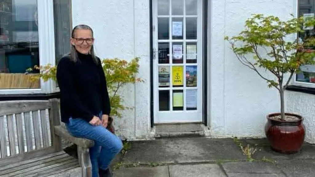 Hazel Cranstoun sits on a bench in front of the village shop in Pirnmill.