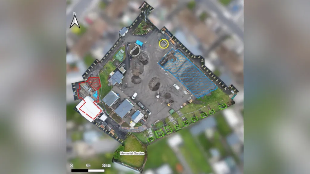 An aerial view of the excavation site at Tuam. A small area in the left corner of the site is outlined in red, a large section to the right is outlined in blue and there is a small section beside it there is a yellow circle and to the bottom there nine small squares marked in green lines.