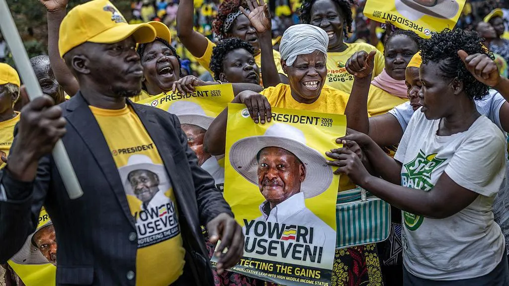 Supporters of Uganda's incumbent president and National Resistance Movement (NRM) presidential candidate Yoweri Museveni 9wearing yellow jerseys, hold electoral posters and dance in celebration during a party gathering