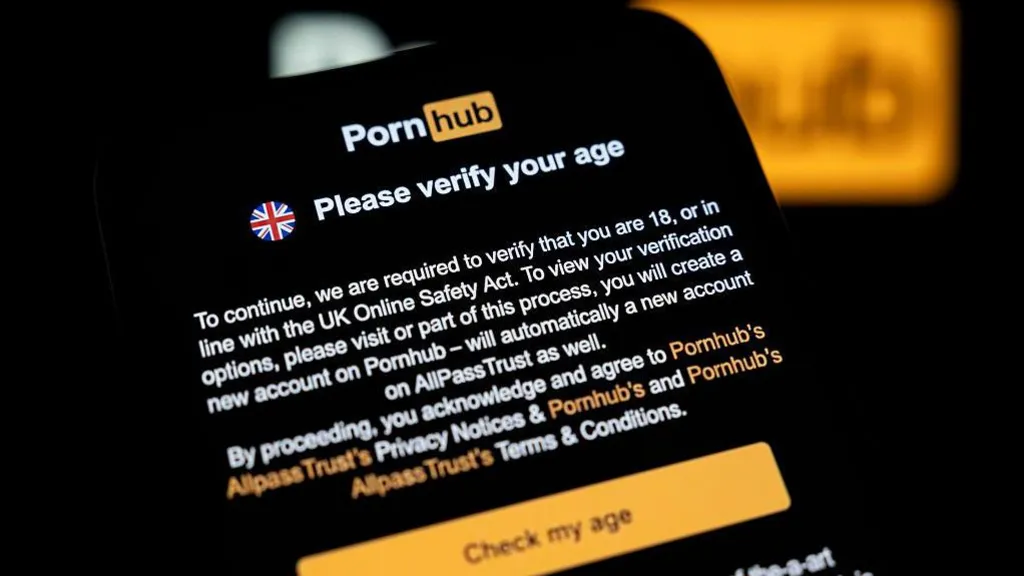A pop-up notification on Pornhub's UK website says "Please verify your age". It explains under the Online Safety Act it must verify the age of visitors and make sure they are 18 or older. The message adds that to see its options, users must make a Pornhub account. Below the message is a highlighted yellow box prompting users to "check my age" and continue.