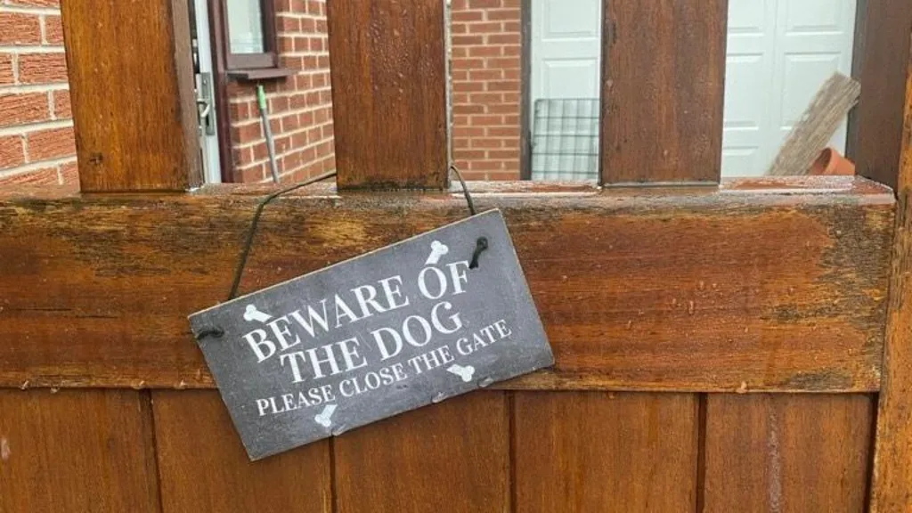 Sign reading 'Beware of the dog: Please close the gate' on Liz's gate post. 
