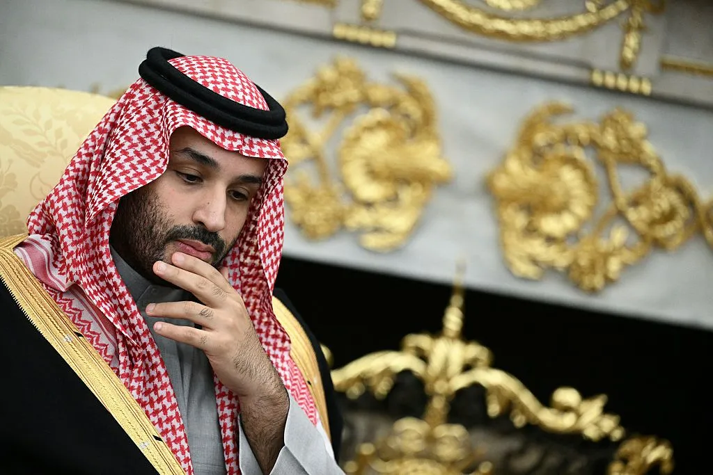 Saudi crown prince Mohamed bin Salman on the left of the photo looks down and puts his hand to his chin