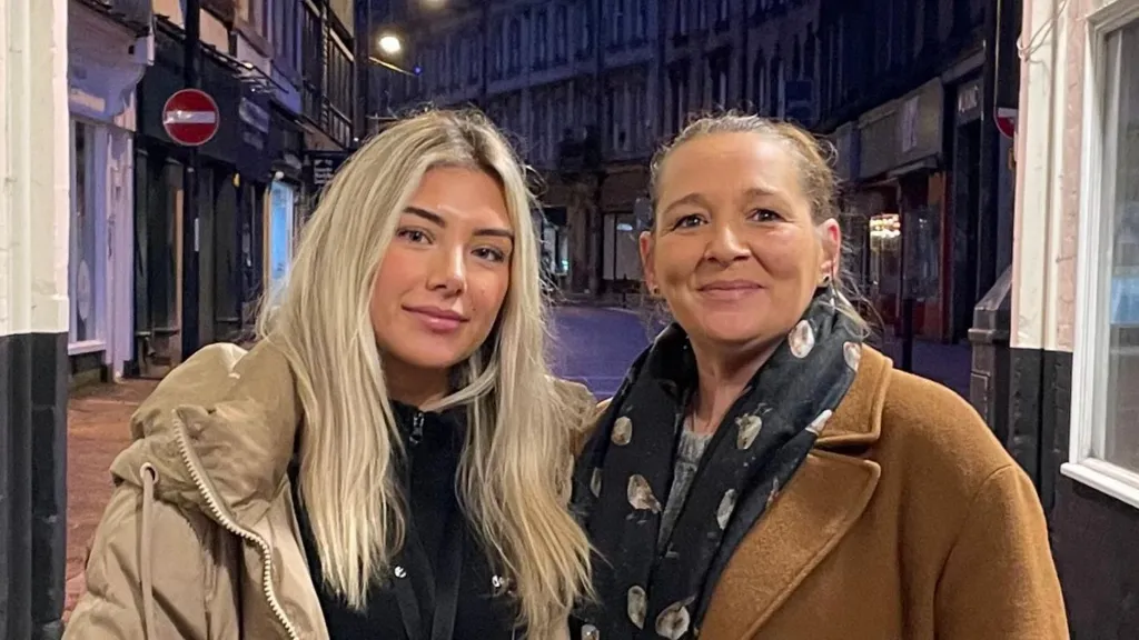 Daisy and Emma and wearing warm jackets and standing at the entrance of a rough sleeping hotspot