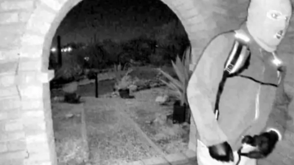 Police have released black and white images of a masked person, that show the person in gloves, a zippered sweater approaching the home at night. 