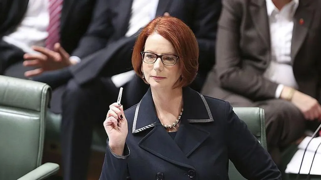 A female politician sitting in parliament, with short red hair and wearing a dark suit.