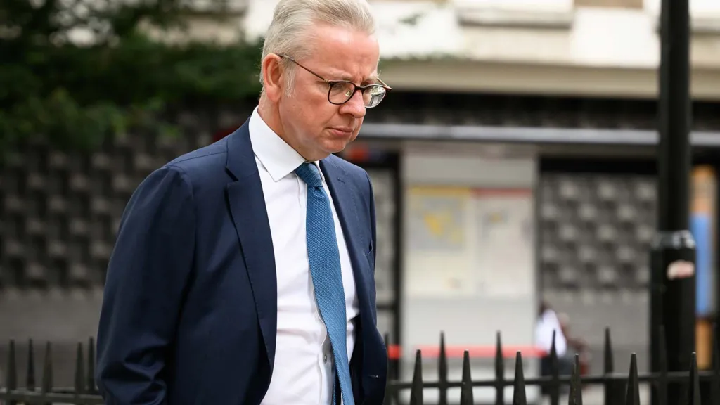 Michael Gove looking at the ground and looking contemplative, walking along Downing Street