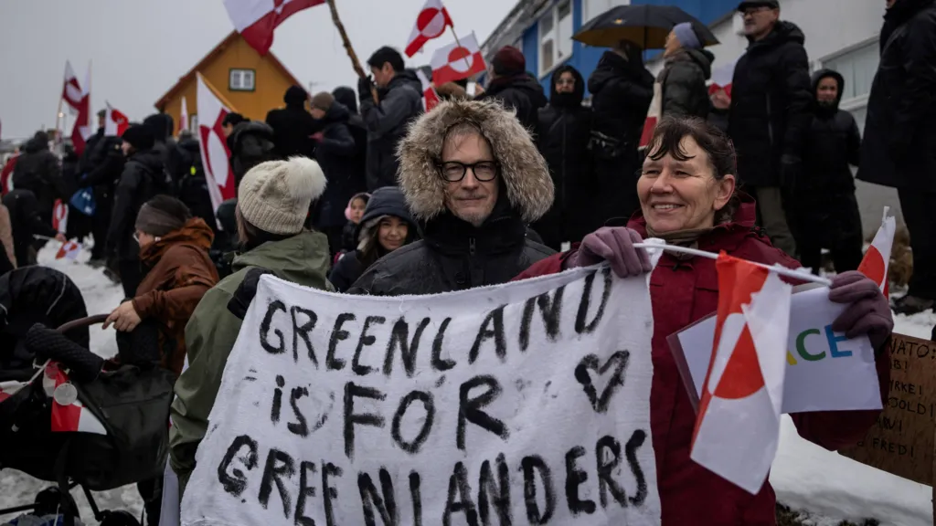 People attend a protest against U.S. President Donald Trump's demand that the Arctic island be ceded to the U.S., calling for it to be allowed to determine its own future, in front of the U.S. consulate in Nuuk, Greenland, January 17, 2026. They're holding a banner reading, Greenland is for Greenlanders