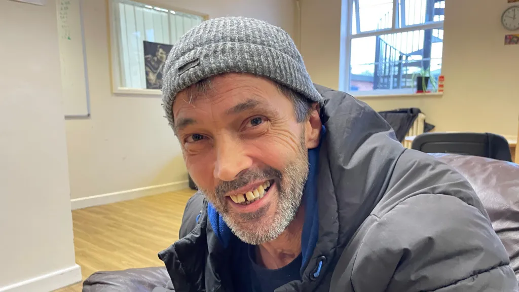 David is wearing a woolly hat and smiling