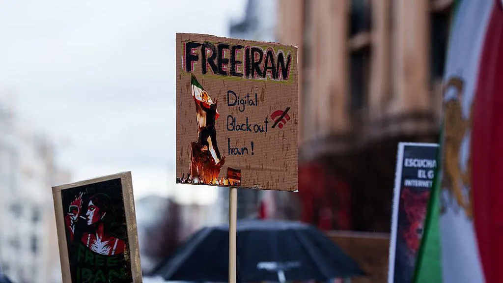 image of a cardboard protest sign, reading "Free Iran, Digital Blackout Iran"