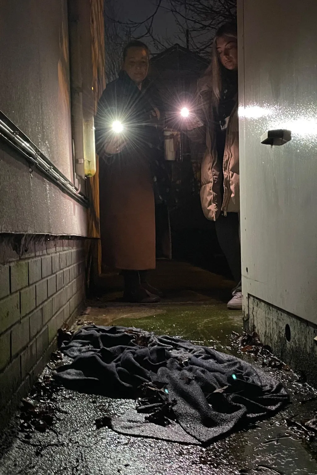 Two torches illuminate a dark, wet blanket