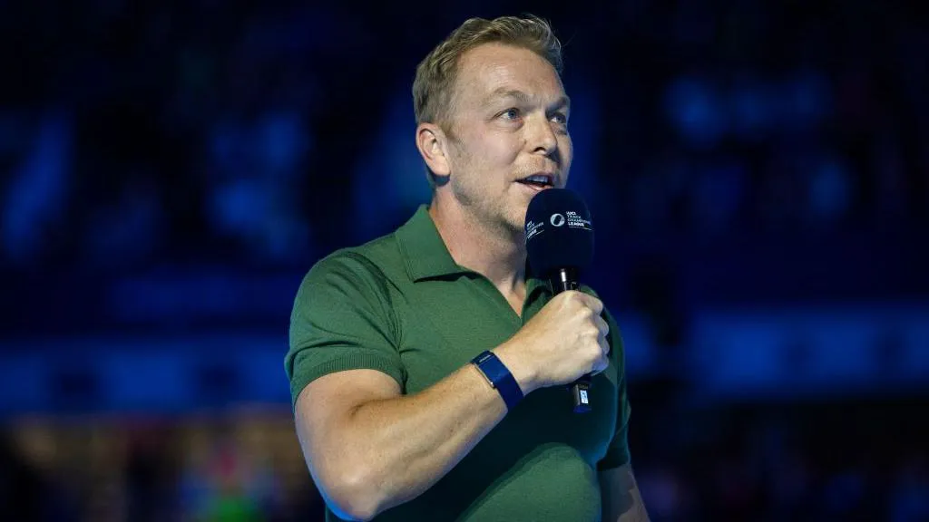 Former track cyclist and Olympian Sir Chris Hoy addresses a crowd at Lee Valley Velopark Velodrome on 7 December, 2024. He wears a short sleeved green polo shirt and holds a microphone 