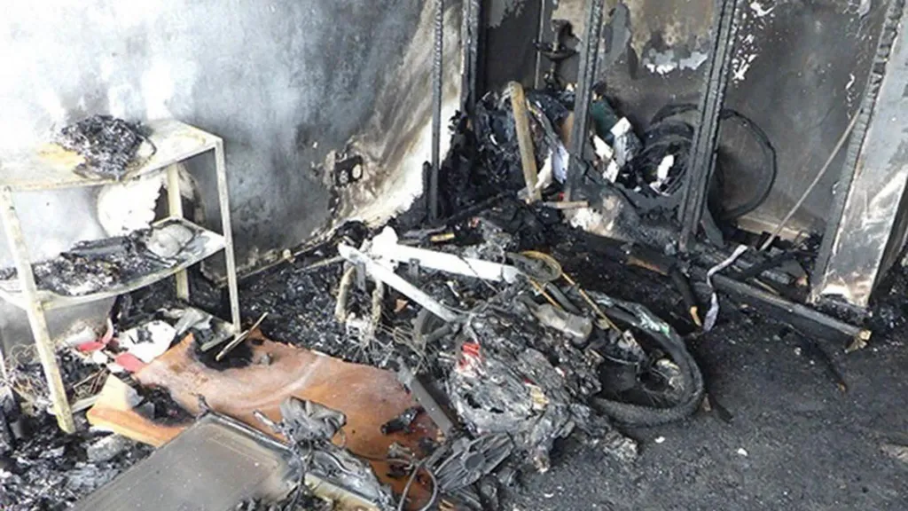 The charred remains of an e-bike sit in a burnt-out room.