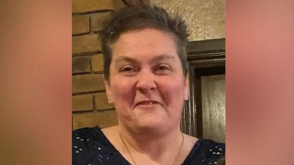 Ann Marshall is smiling at the camera. She has short brown hair and is wearing a black top.