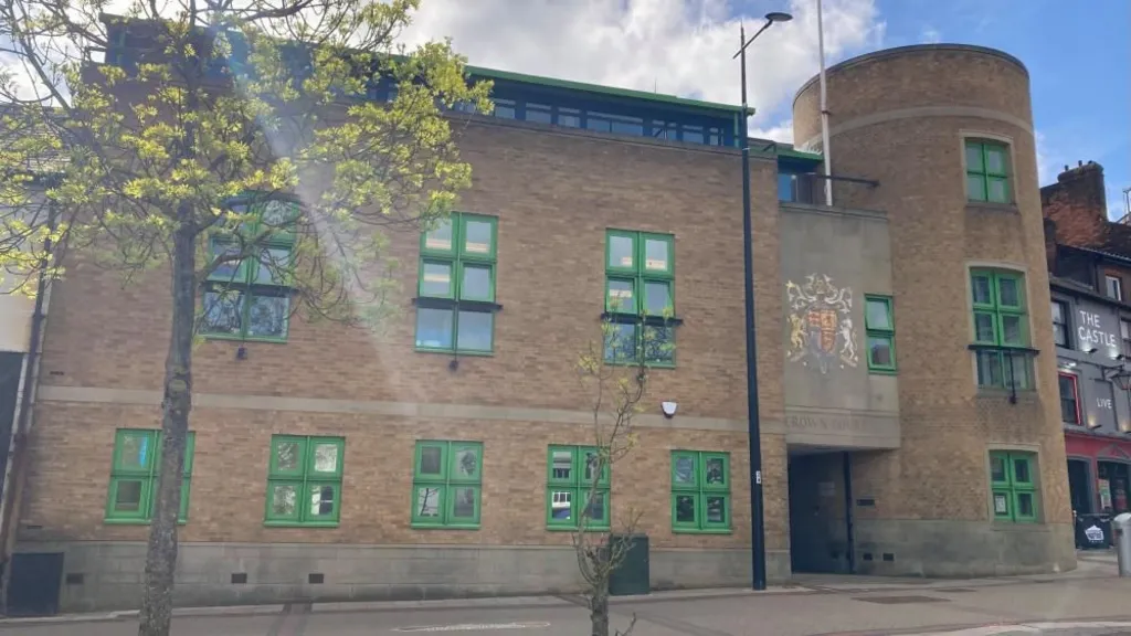 Luton Crown Court: a brown brick building with green framed windows. A sign, beneath a crest, over the entrance says "crown court" in capital letters.