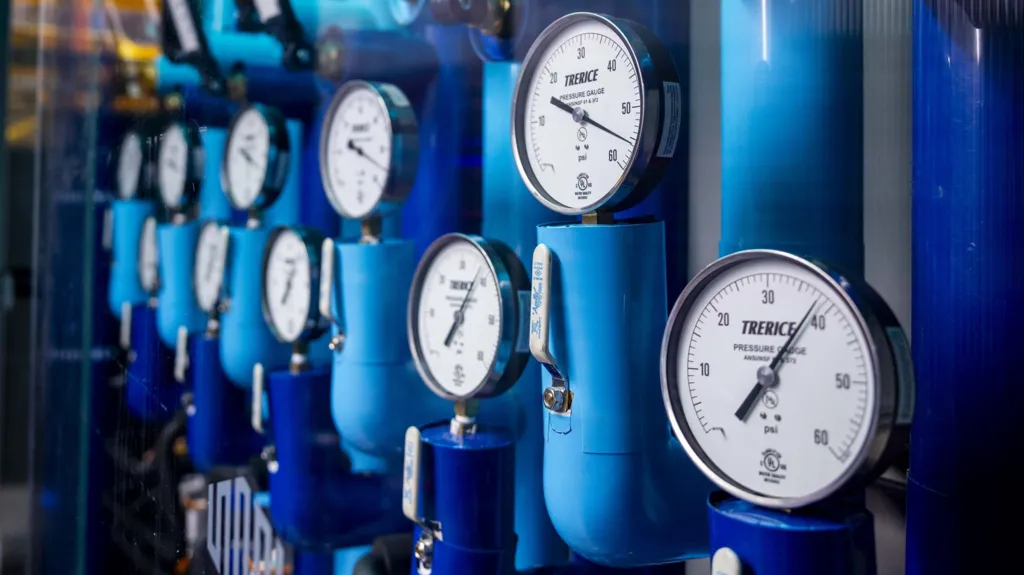 Pressure gauges attached to blue pipes at a data centre