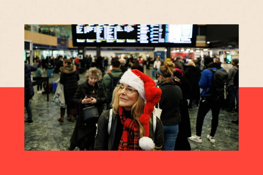 A commuter in a Christmas hat waits for a train