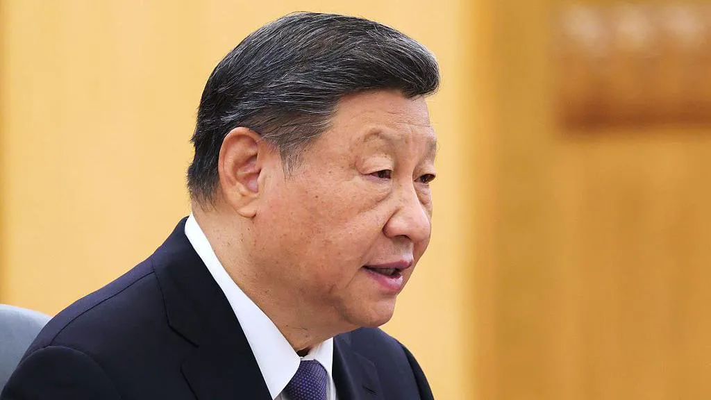 Profile shot of Xi Jinping wearing a navy blue suit and white shirt