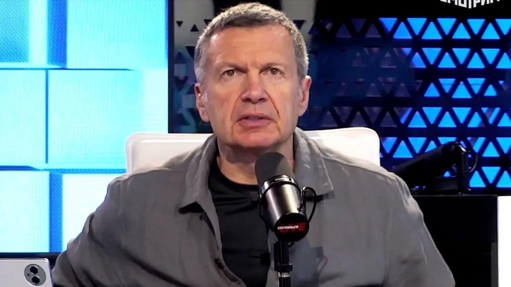 Russian TV presenter Vladimir Solovyov is seen looking into the camera in front of a microphone, on the set of his programme Solovyov Live