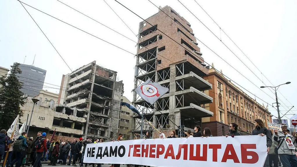A banner saying "we won't surrender the Generalstab" is held outside the ruins in Belgrade