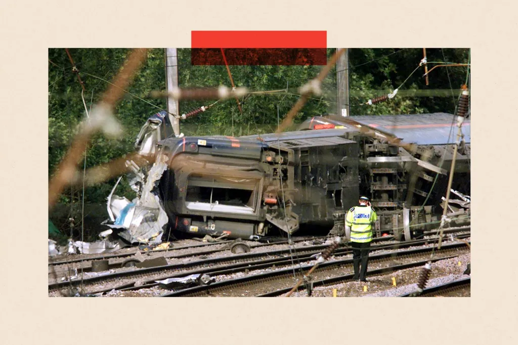  A policeman walks towards the carriages which overturned near Hatfield