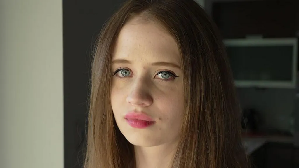 A portrait of Viktoria, a young woman with long, brown hair and blue eyes, pictured close-up and facing the camera
