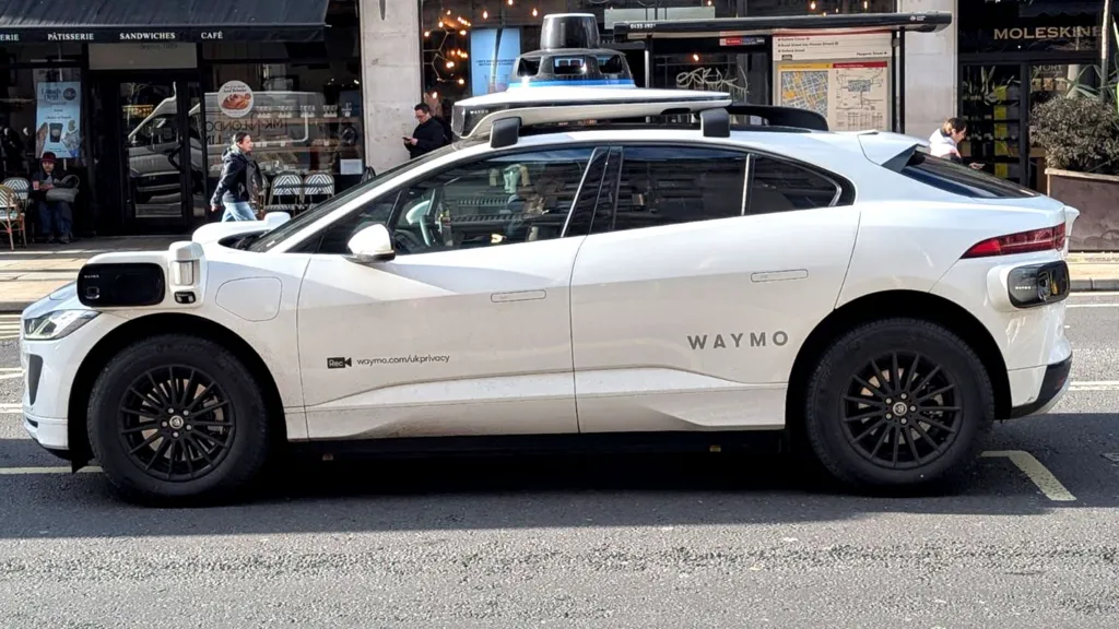 A Waymo car seen on a London road, driven by a driver
