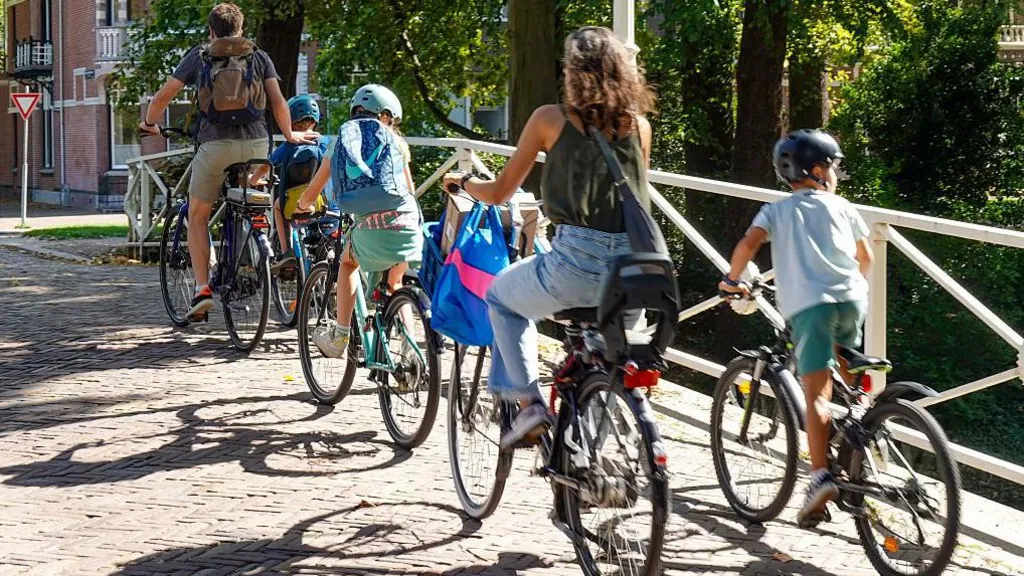 A Dutch family cycling over a bridge