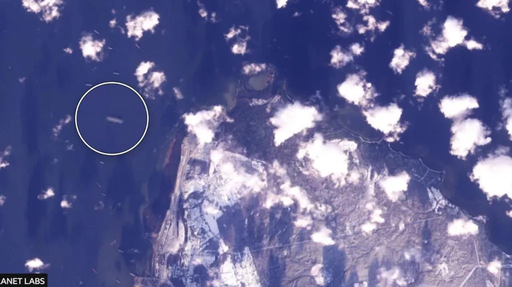 A satellite image of a coastline which is surrounded by vessels