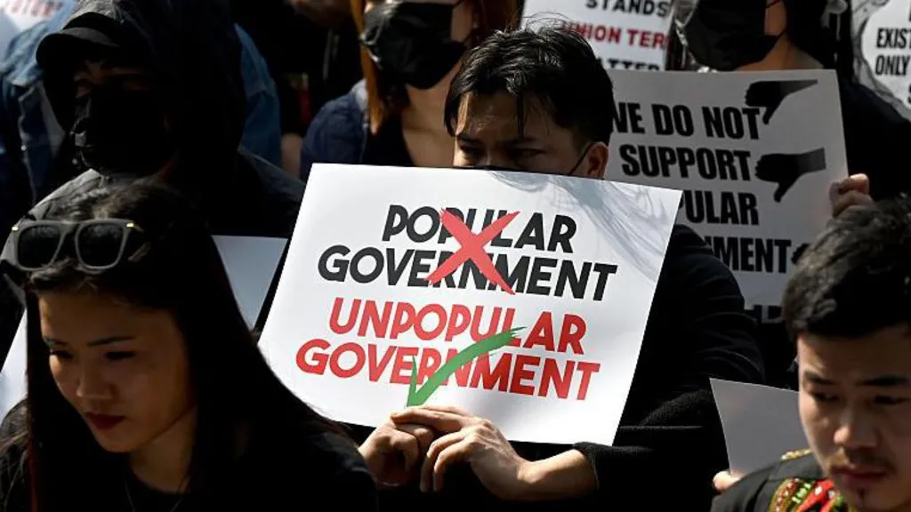 Students, young professionals and activists of Kuki-Zo community holding placards. One of them calls the reinstated elected government an "unpopular government". 