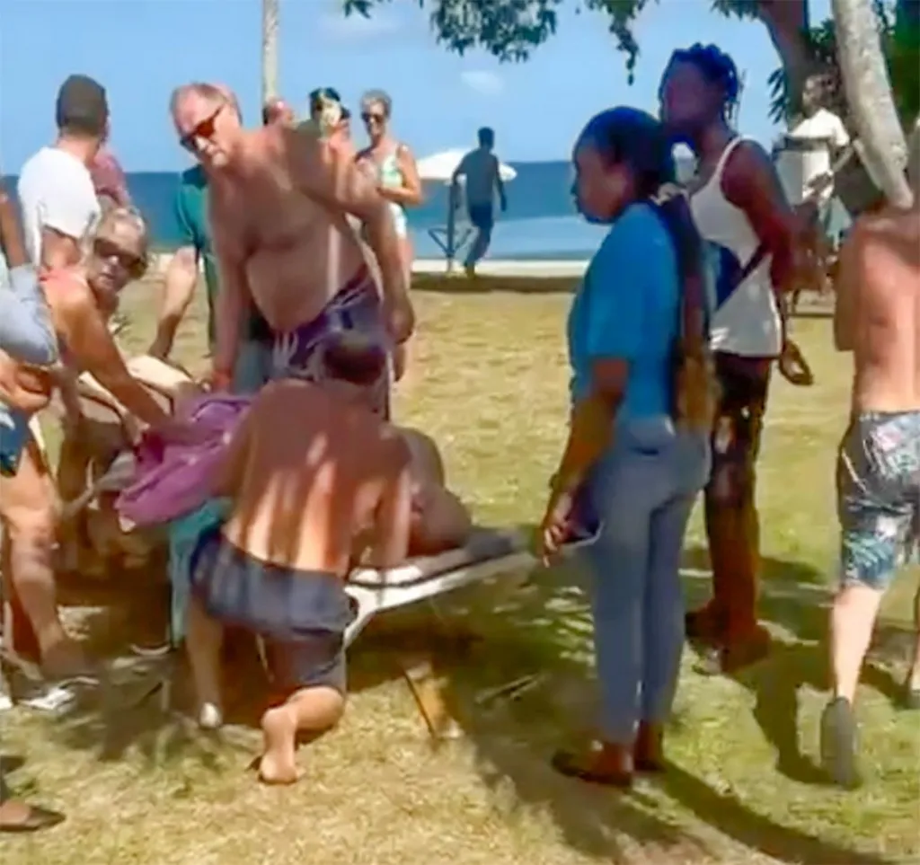 Peter lying on the beach after the attack, surrounded by people 